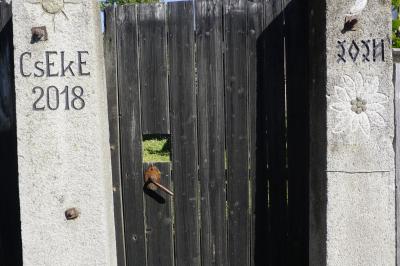 A faragott kapuoszlopok, rajtuk a CsEKE és az évszám